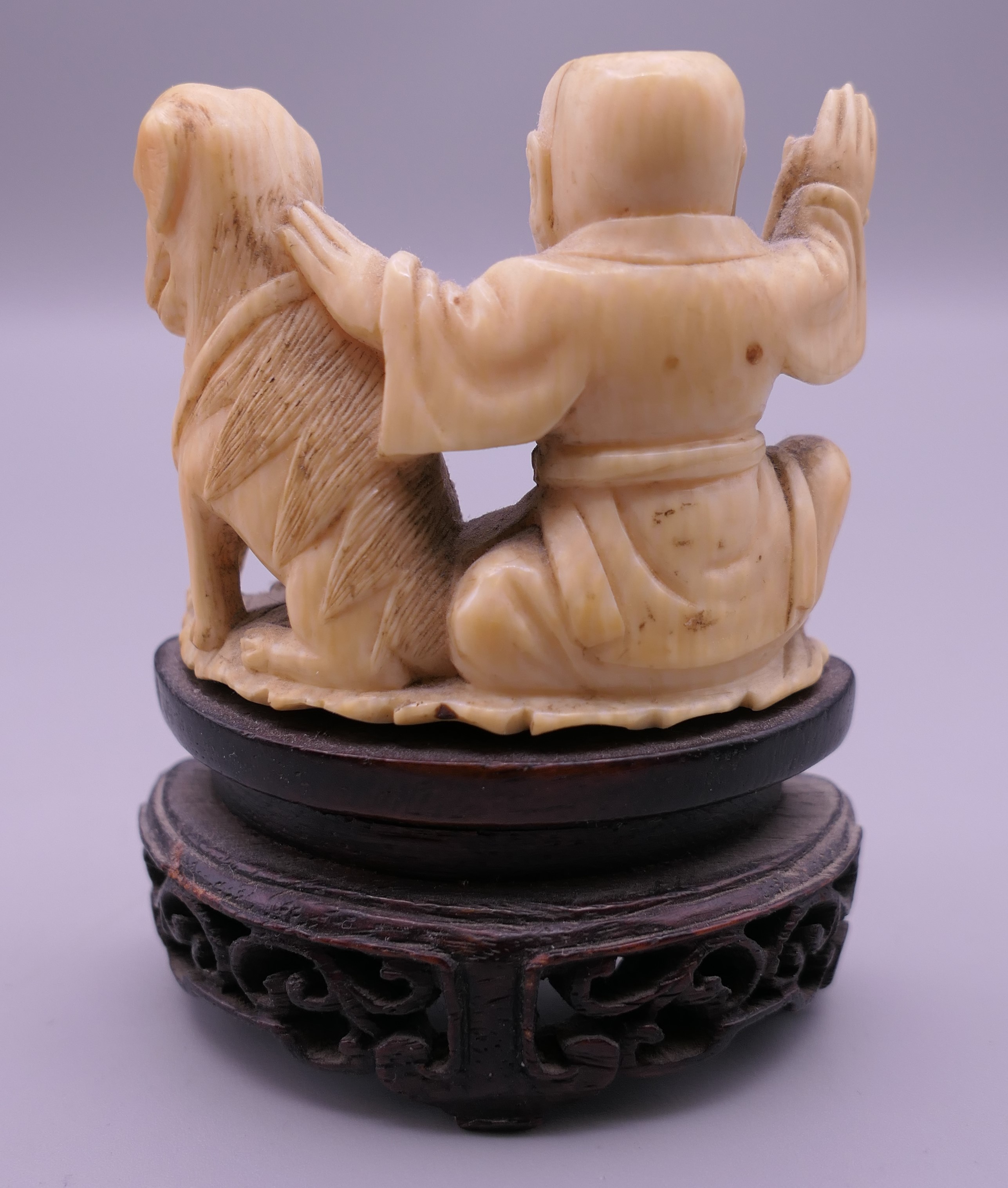 A 19th century Chinese carved ivory model of a boy and dog, mounted on a pierced wooden stand. 7. - Image 3 of 5