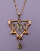 An Art Nouveau 9 ct gold peridot pendant on a 9 ct gold chain. The pendant 4 cm high. 4.