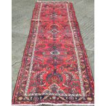 A red ground Hamadan runner. 388 x 86 cm.