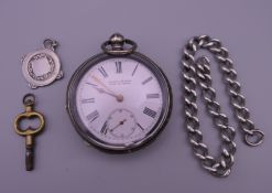 A silver Kendal and Dent pocket watch, a small silver chain and a silver fob.
