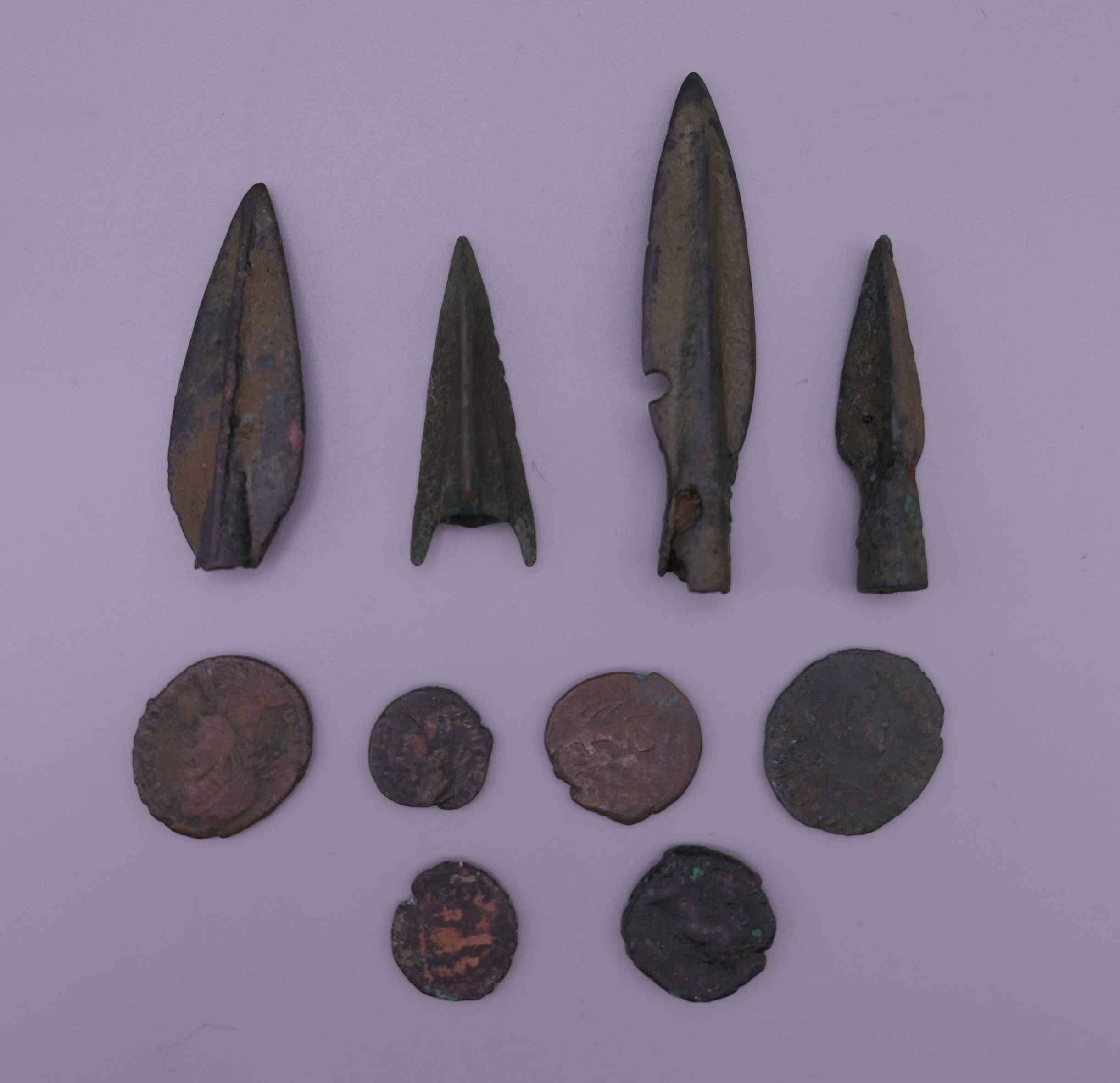 Four Iron Age arrowheads and a quantity of ancient coins.