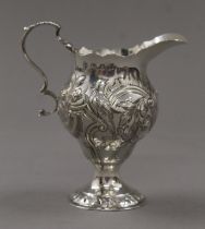 An embossed Georgian silver cream jug. 11.5 cm high. 98.9 grammes.
