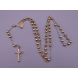 A 9 ct gold rosary bead necklace with crucifix pendant. 20.5 grammes.