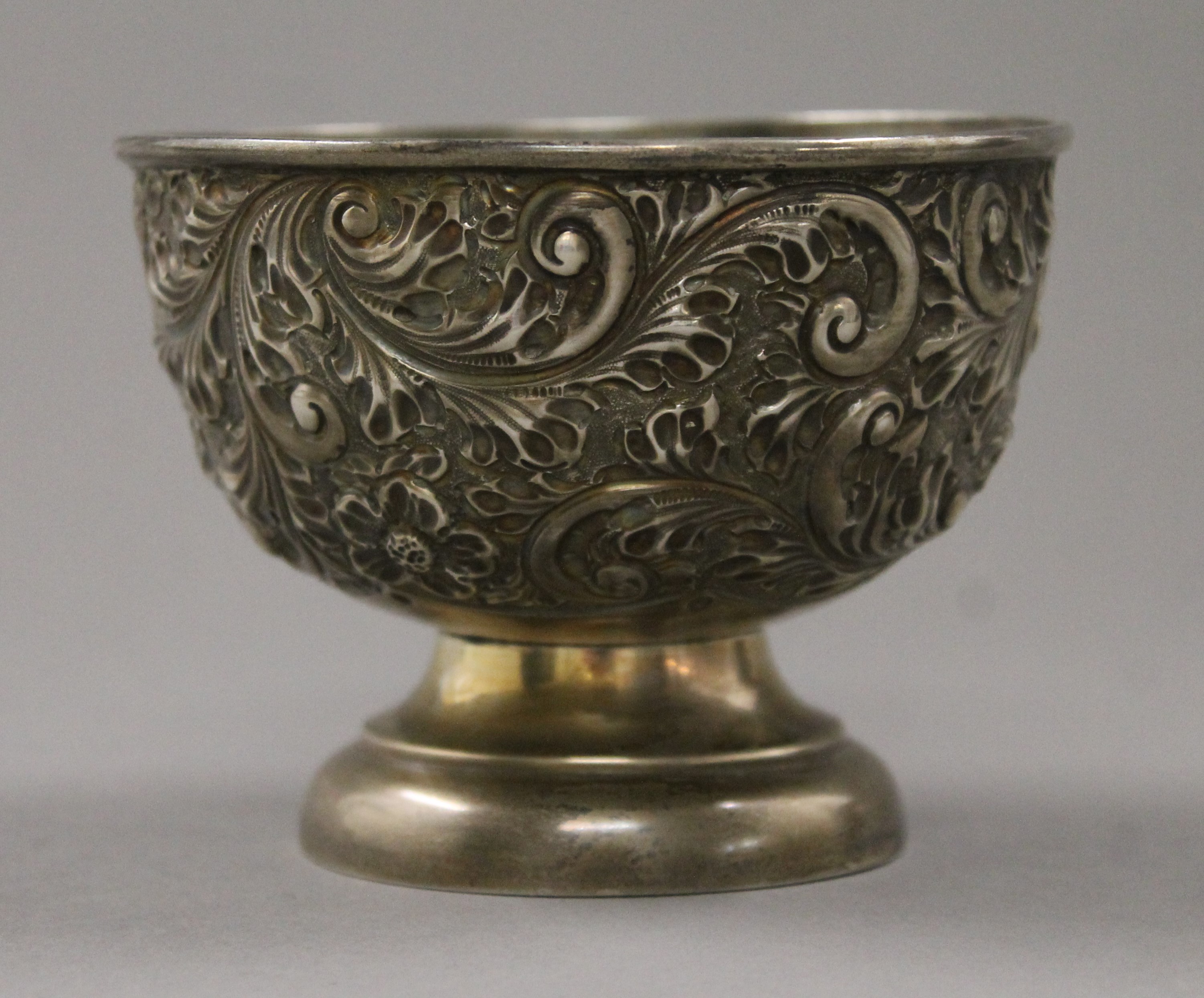 A silver embossed bowl. 8 cm high.