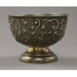 A silver embossed bowl. 8 cm high.
