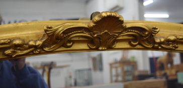 A large gilt framed wall glass. 115 cm wide.