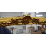 A large gilt framed wall glass. 115 cm wide.