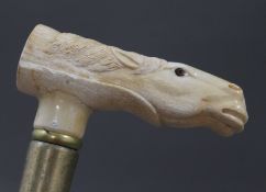A walking stick with a carved bone handle formed as a horse. 92 cm long.