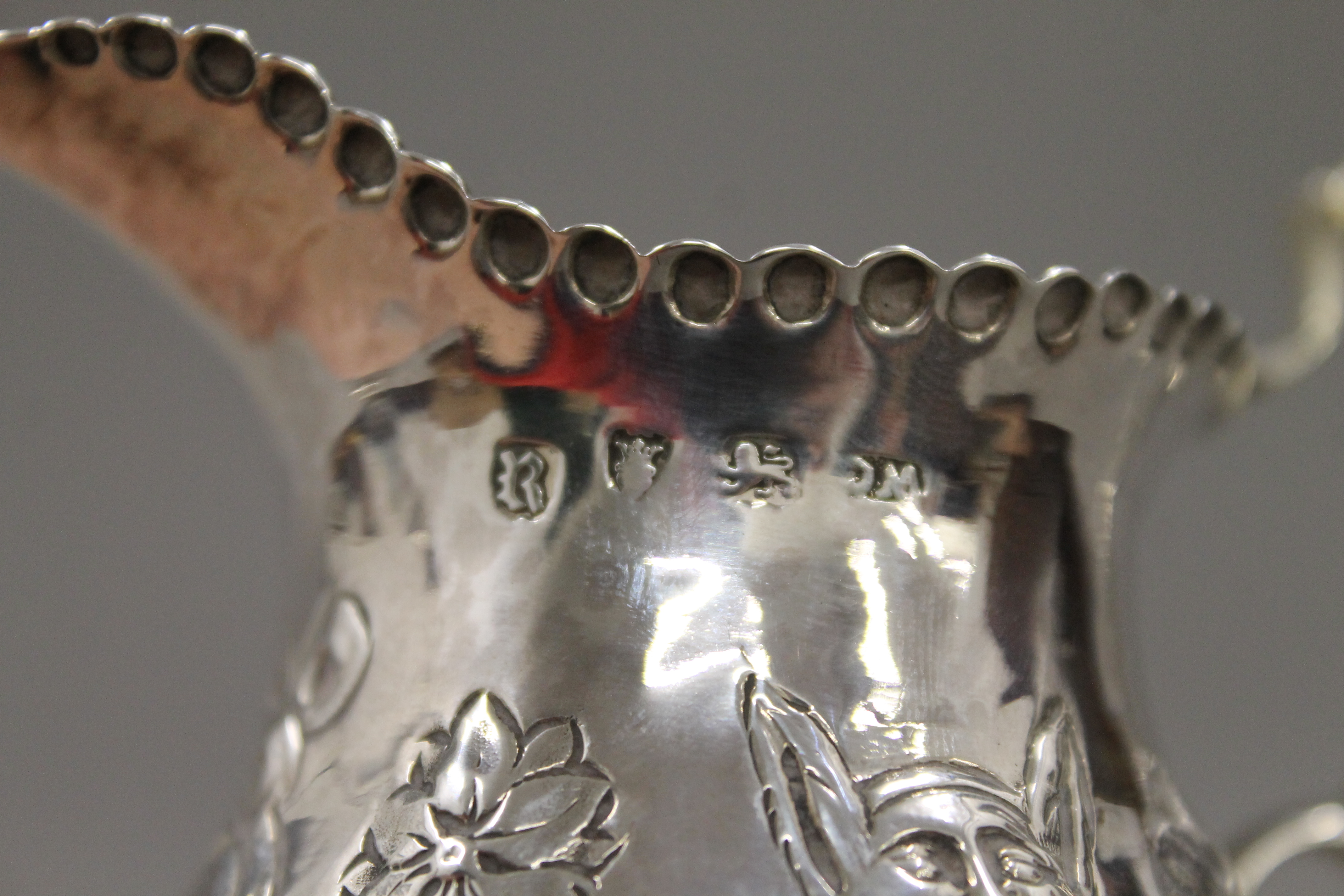 An embossed Georgian silver cream jug. 10.5 cm high. 91.5 grammes. - Image 4 of 5