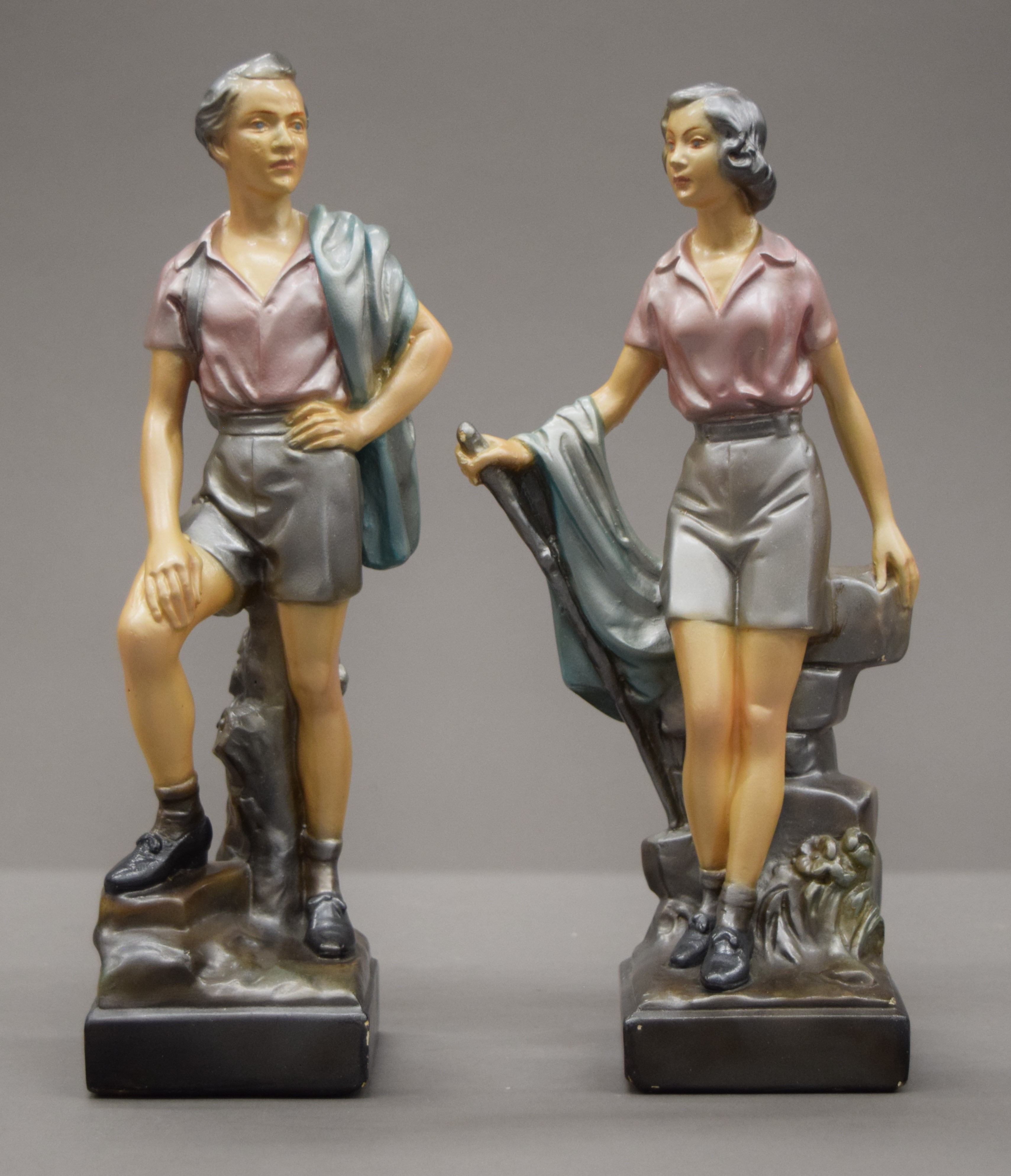 A pair of early 20th century painted plaster models of hikers. The largest 26 cm high.