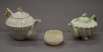 Two Belleek black mark porcelain teapots and a sugar bowl. The largest 15 cm high.