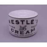 A Nestle's Pure Thick Cream stoneware advertising paperweight. 3.75 cm high.