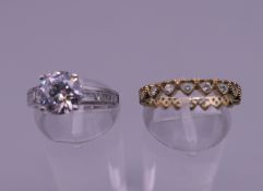 A white metal stone set ring and a yellow metal stone set ring.