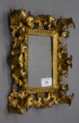 A 19th century Florentine carved gilt wood picture frame set with a mirror plate. 21 x 24.