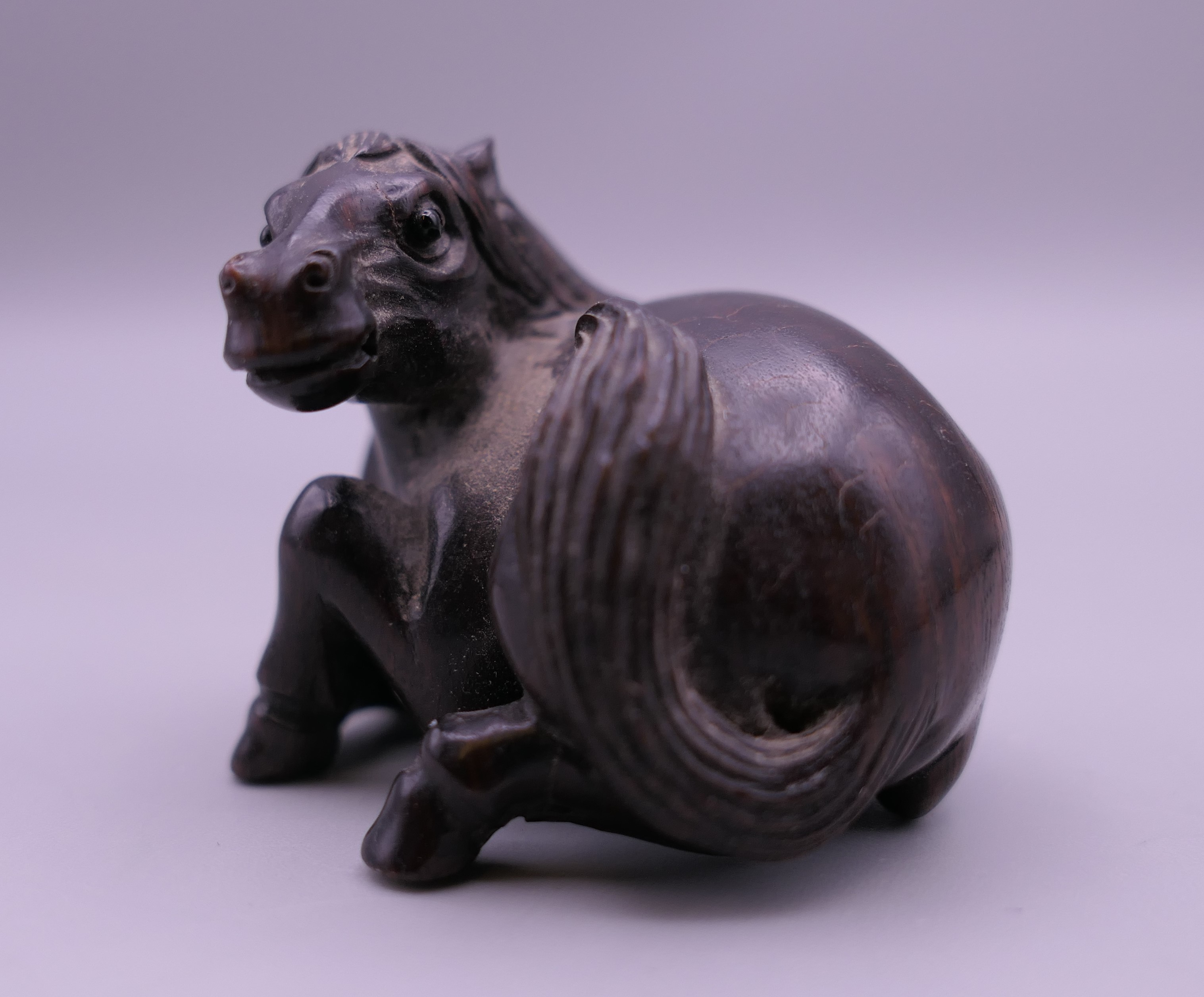 A carved wooden netsuke formed as a horse. 3.5 cm high. - Image 2 of 5