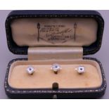 A cased set of three 9 ct gold studs. 2.9 grammes total weight.