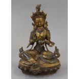 A gilt bronze model of buddha decorated with coral. 21 cm high.