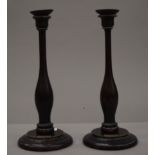 A pair of candlesticks, each bearing label inscribed Made from the Timber taken from H.M.