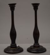 A pair of candlesticks, each bearing label inscribed Made from the Timber taken from H.M.