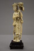 A 19th century Chinese carved ivory figure of Guanyin, mounted on a pierced wooden stand. 23.