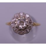 An unmarked gold diamond flowerhead ring. Ring size O. 2.4 grammes total weight.
