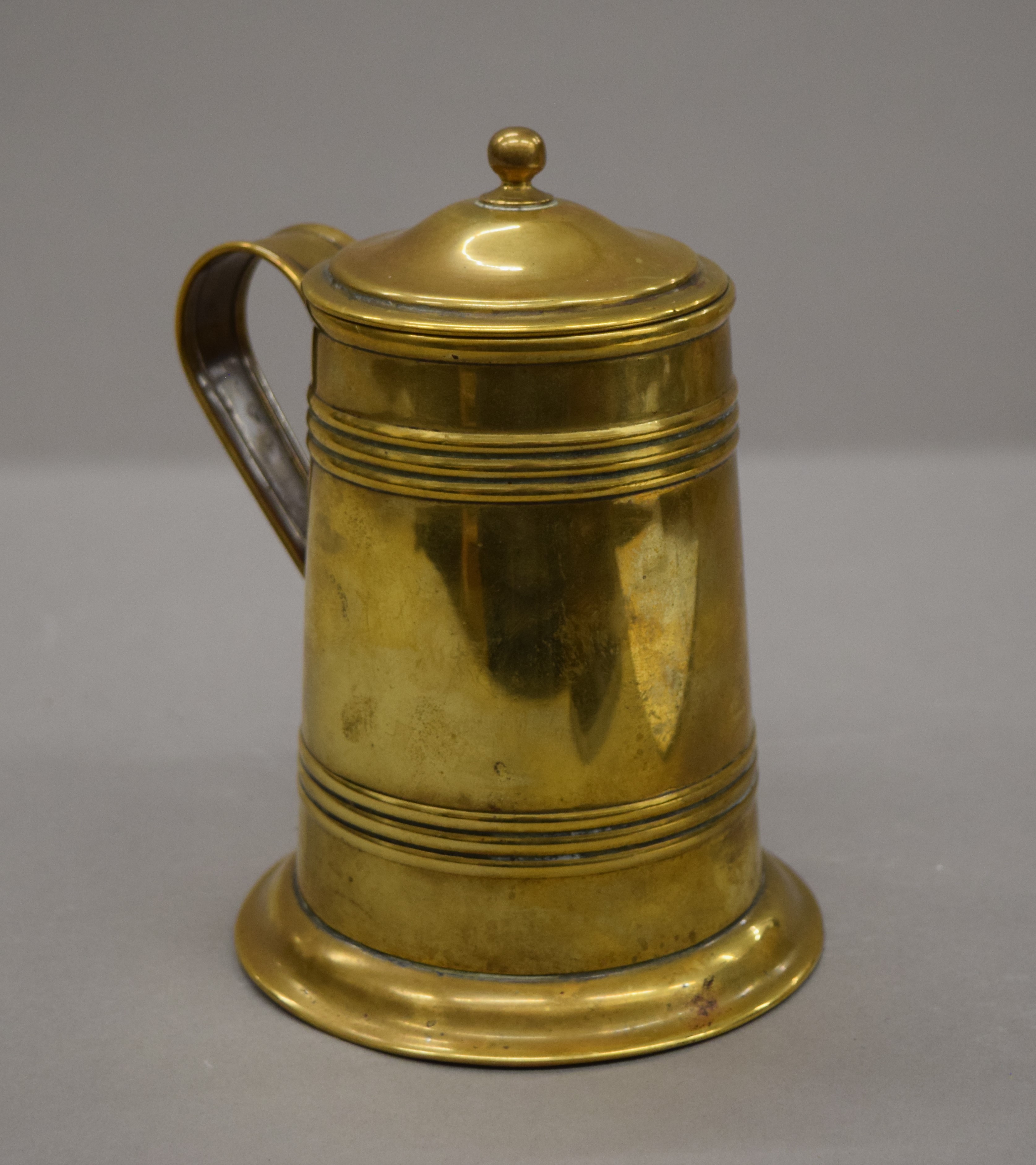 An army and navy brass lidded tankard. 14 cm high.