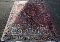 A large Persian red ground wool rug. 345 x 250 cm.