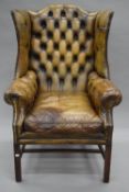 A mahogany framed leather wing back arm chair. 79 cm wide.