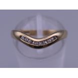 A 9 ct gold diamond wishbone ring. Ring size L. 1.8 grammes total weight.