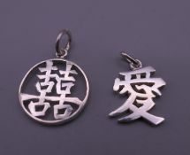 Two Chinese white metal pendants. The largest 2 cm high.