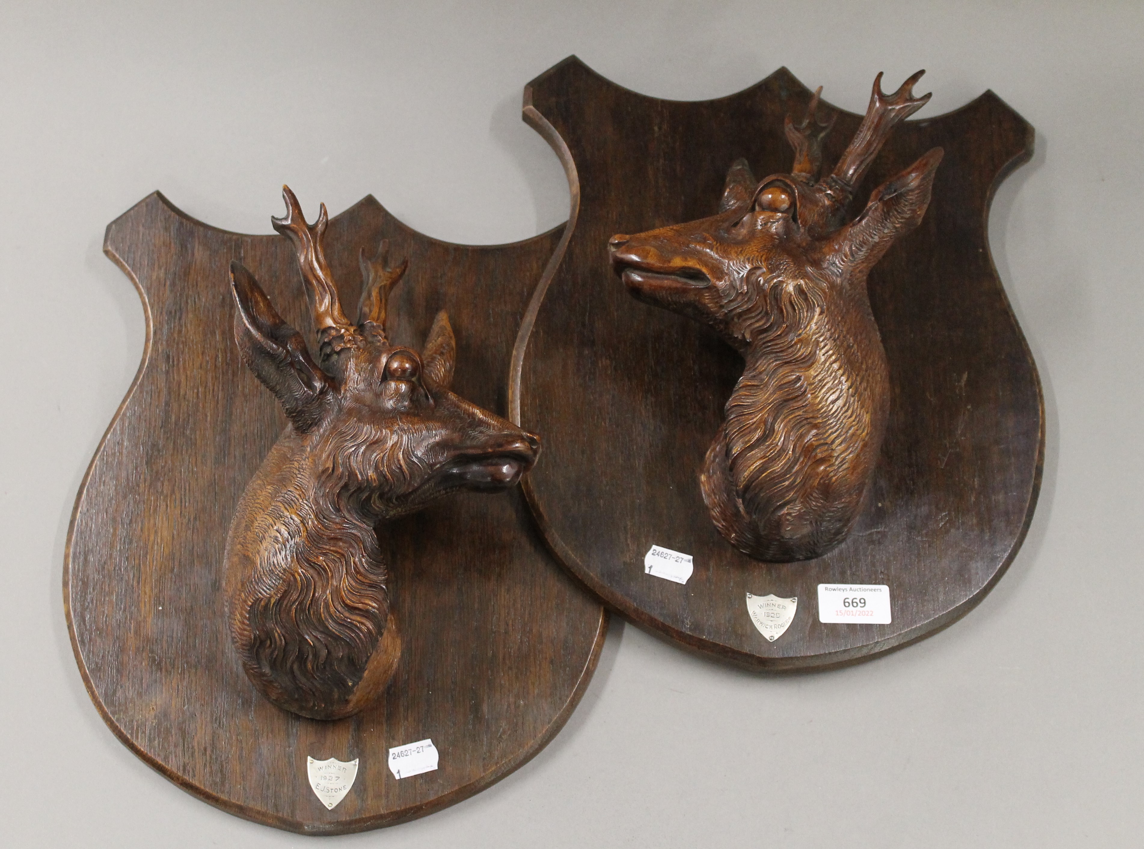 A pair of carved 1920's stag head trophy shields. 37 cm high.