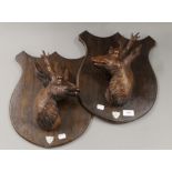 A pair of carved 1920's stag head trophy shields. 37 cm high.