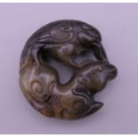 A Chinese carved jade roundel. 5 cm diameter.