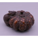A netsuke formed as a rat and a fruit. 4 cm wide.