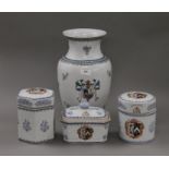 A porcelain vase decorated with a heraldic crest and three similar lidded pots.