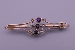 An Edwardian 9 ct gold amethyst and seed pearl brooch. 4.5 cm long. 2.4 grammes total weight.