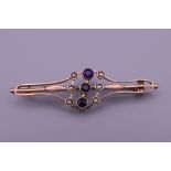 An Edwardian 9 ct gold amethyst and seed pearl brooch. 4.5 cm long. 2.4 grammes total weight.