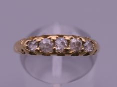 An 18 ct gold diamond five stone ring. Ring size O/P.