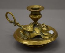 A Victorian brass chamberstick in the form of a saddle, etc. 10 cm high.