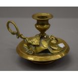 A Victorian brass chamberstick in the form of a saddle, etc. 10 cm high.