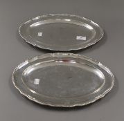 A pair of George III silver serving platters, each engraved with a crest, hallmarked London 1773.
