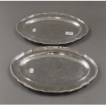 A pair of George III silver serving platters, each engraved with a crest, hallmarked London 1773.