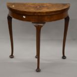 A walnut demi lune card table. 78 cm wide.