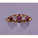 A 15 ct gold diamond and ruby five stone ring. Ring size S/T. 2.3 grammes total weight.