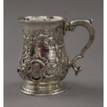 A Georgian silver tankard with later embossed decoration. 10 cm high. 221.8 grammes.
