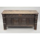 An 18th century carved oak coffer. 140 cm long.