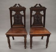 A pair of Victorian carved hall chairs. 46 cm wide.