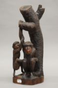 A carved wooden model of two monkeys beside a tree. 37 cm high.