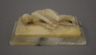 An alabaster carving of a figure. 16.5 cm long.