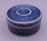 A Continental blue enamel decorated silver box. 4.5 cm diameter.